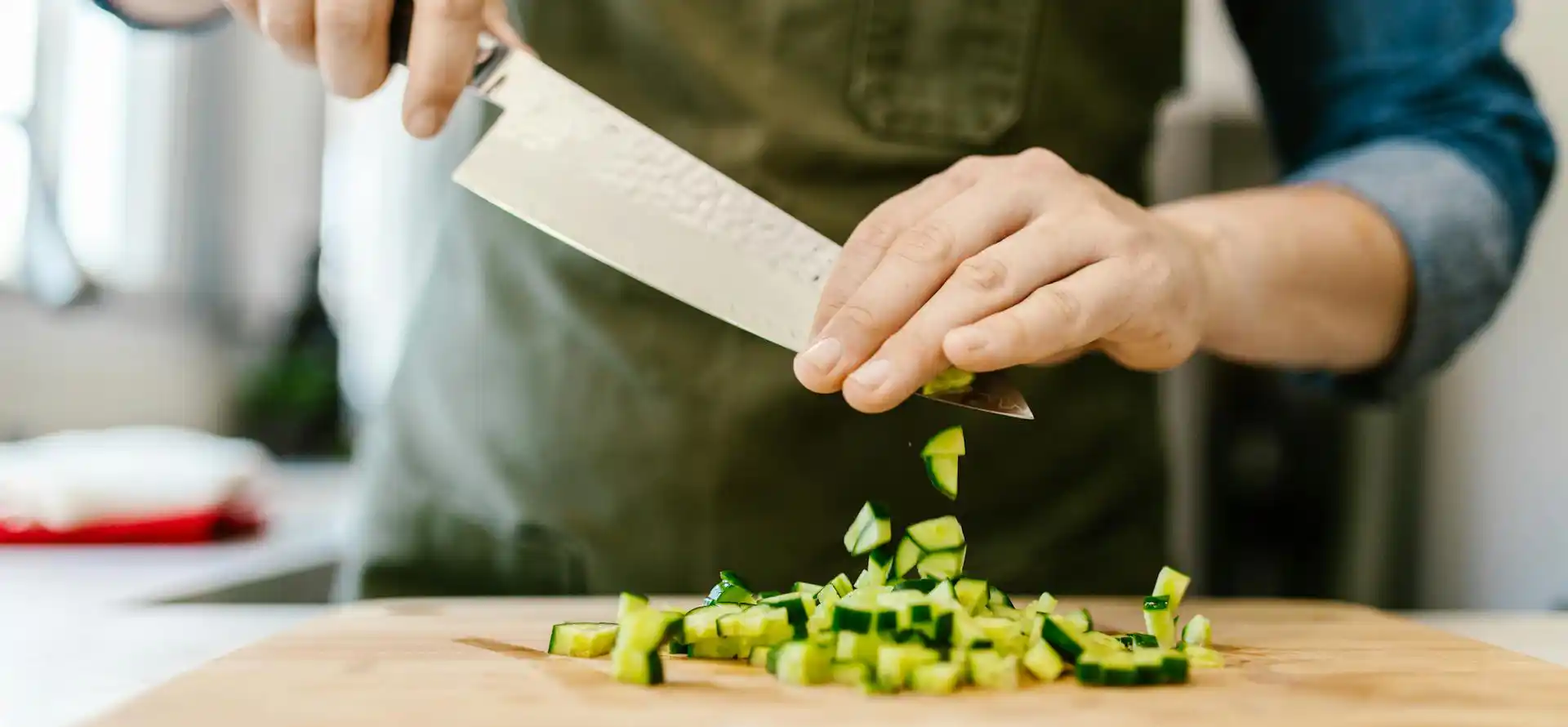 Mann hackt Zucchini auf Schneidbrett