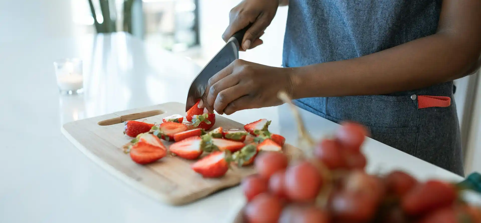 Frau schneidet frische Erdbeeren in Küche